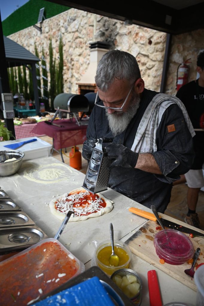 אני עובד בעמדה מגרד גבינה טבעונית על פיצה