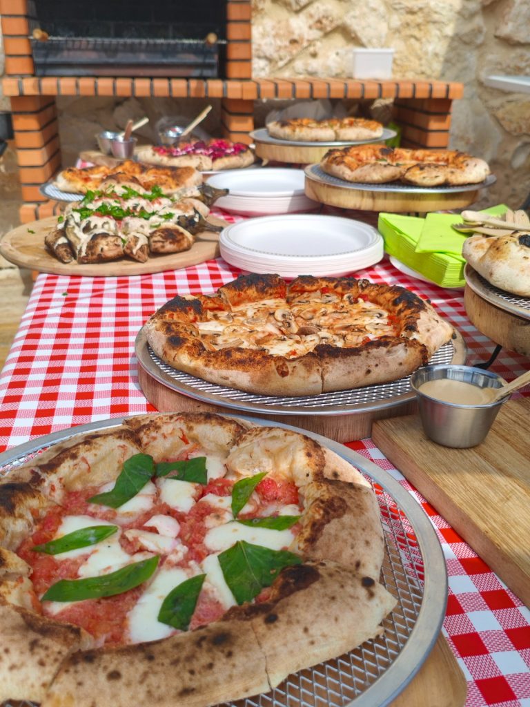 מבט מהצד שולחן עמוס פיצות, מטבלים ופוקצות